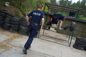 policjanci biegną przez przeszkody i strzelają z pistoletów do tarcz na strzelnicy