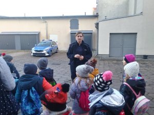 Policjantka na dziedzińcu znińskiej komendy wspólnie z dziećmi.