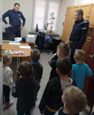 Dzielnicowy przedstawia maluchom pełniącego obowiązki Kierownika Posterunku Policji w Łabiszynie asp. szt. Daniela Maciejewskiego.