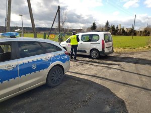 Policjant kontroluje kierującego samochodem osobowym, który przekroczył dozwoloną prędkość.