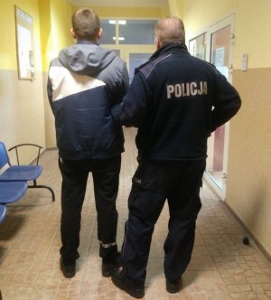 W budynku Komendy Powiatowej Policji w Żninie policjant wraz z zatrzymanym  19-latkiem.