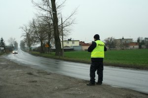 Policjant ruchu drogowego obserwuje nadjeżdżający pojazd.