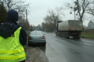 Funkcjonariusz obserwuje ruch nadjeżdżających pojazdów.