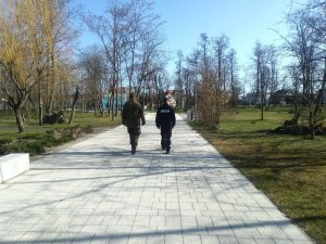 Policjant i funkcjonariusz WOT podczas wspólnego patrolu w parku miejskim.