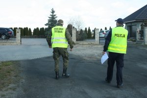 Funkcjonariusz WOT i dzielnicowy podczas wspólnego patrolu na obrzeżach miasta Żnina.