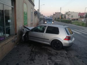 pojazd osobowy, który uszkodził ścianę  budynku