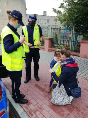 policjanci wręczyli dziewczynce kamizelkę odblaskową