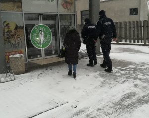 Dwóch Policjantów  oraz pracownik Sanepidu wchodzący do Galerii Handlowej