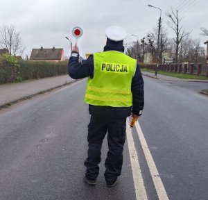 Umundurowany policjant ruchu drogowego stojący na pasie ruchu