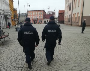 dwóch policjantów idący przez rynek miasta