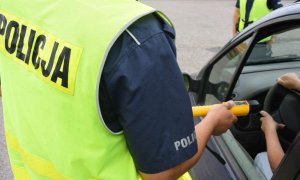 policjant  trzymający w  ręku Alcoblow, urządzenie do  badania trzeźwości