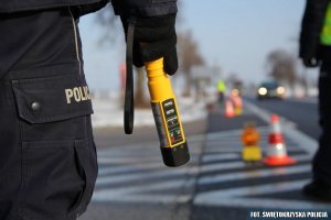 na zdjęciu widoczny jest policjant trzymający urządzenie do badania trzeźwości