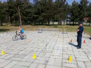 Na obrazku widać policjanta  i chłopca na rowerze