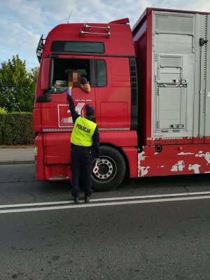 obrazek przedstawia policjanta który kontroluje stan trzeźwości, kierującego samochodem ciężarowym