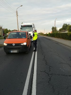 obrazek przedstawia funkcjonariusza, który bada trzeźwość kierowcy pojazdu osobowego