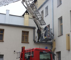 zdjęcie przedstawia strażaka z mężczyzna na podnośniku