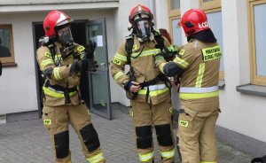 zdjęcie przedstawia strażaków ubranych w maski i aparaty tlenowe