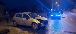 Widok miejsca zdarzenia. Z lewej strony uszkodzony pojazd marki Opel. W oddali droga K5 oraz policyjny nieoznakowany radiowóz.