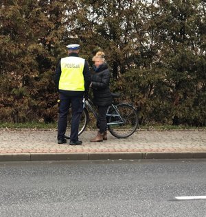 Policjant kontroluje rowerzystę.