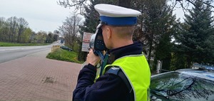 Policjant wykonuje pomiar prędkości przy użyciu laserowego miernika