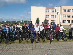 uczniowie z rowerami, policjantki i nauczycielka  stoją na  płycie  boiska