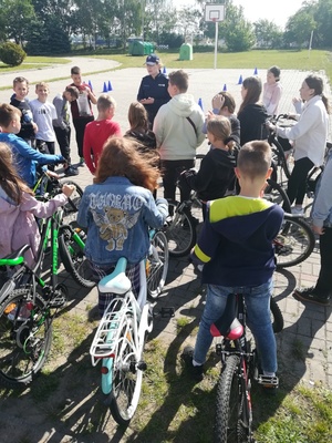 policjantka  rozmawia z grupą dzieci, które  mają ze sobą rowery