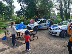 Stoisko Komendy Powiatowej Policji w Żninie i Posterunku Policji w Łabiszynie. Na stoisku sprzęt policyjny do zabezpieczenia imprez masowych. Z prawej strony dwa radiowozy policyjne, przy których stoi dzielnicowy. Zainteresowani objadają jego wnętrze.