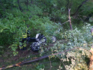 uszkodzony motocykl znajduję się wśród  połamanych gałęzi