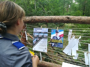 harcerka przywiesza informacje  dotyczące konkursu oraz pracy w Policji