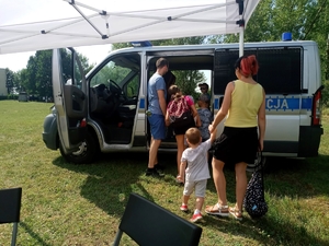 dzieci i osoby  dorosłe gromadzą się przy radiowozie Fiat  Ducato, wchodzą do środkowej części pojazdu