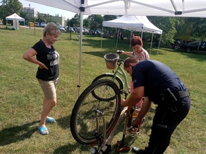 policjant znakuje rower przy  którym czeka  dziewczynka