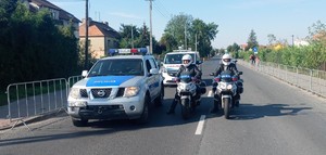 radiowóz policyjny oraz dwóch  policjant na motocyklach policyjnych