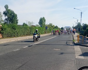 policjant  na  motocyklu pilotuje grupę rowerzystów