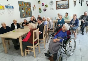 starsze  osoby  siedzą przy stole