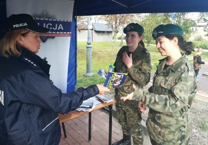 policjanta wręcza żołnierkom ulotkę