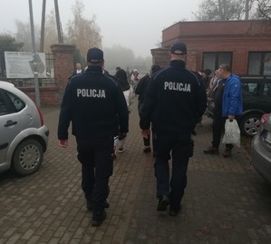 dwóch policjantów  patroluje  rejon cmentarza