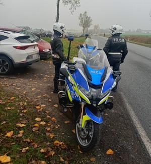 policyjne  motocykle  ustawione  wzdłuż drogi, obok stoją policjanci