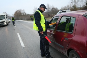 policjant  sprawdza trzeźwość kierującego pojazdem osobowym