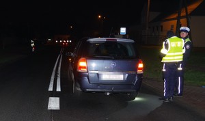 samochód  opel zafira  soi na  pasie  ruchu, obok niego  dwóch policjantów  ruchu drogowego