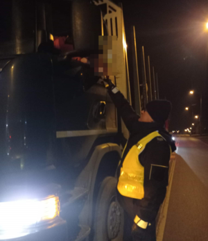 policjant poddaje badaniu stanu trzeźwości kierującego ciężarówką