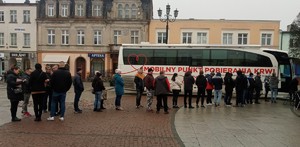 ludzie  ustawieni w  kolejkę przed autobusem