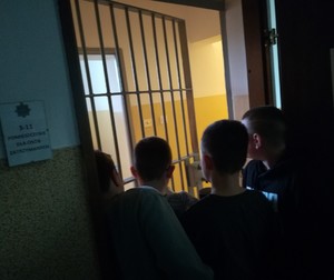 chłopcy stoją przed wejściem  do pomieszczenia  dla  osób  zatrzymanych