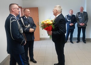 mężczyzna  wręcza policjantom kwiaty