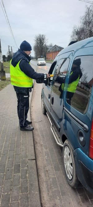 policjant  bada stan trzeźwości kierowcy dostawczaka