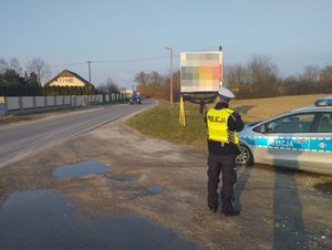 policjant  mierzy  prędkość za  pomocą miernika