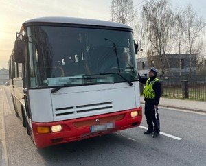 policjant  bada trzeźwość kierowcy autobusu