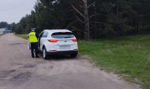 policjant  kontroluje  białe auto