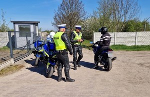 policjanci kontrolują motocyklistę