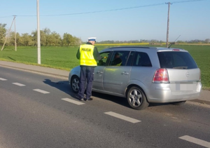 policjant  kontroluje  trzeźowść kierowcy opla