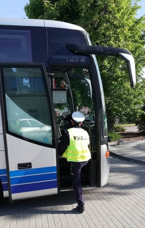 policjant  wchodzi do autokaru